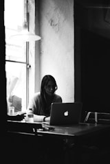 a person sitting at a table with a laptop