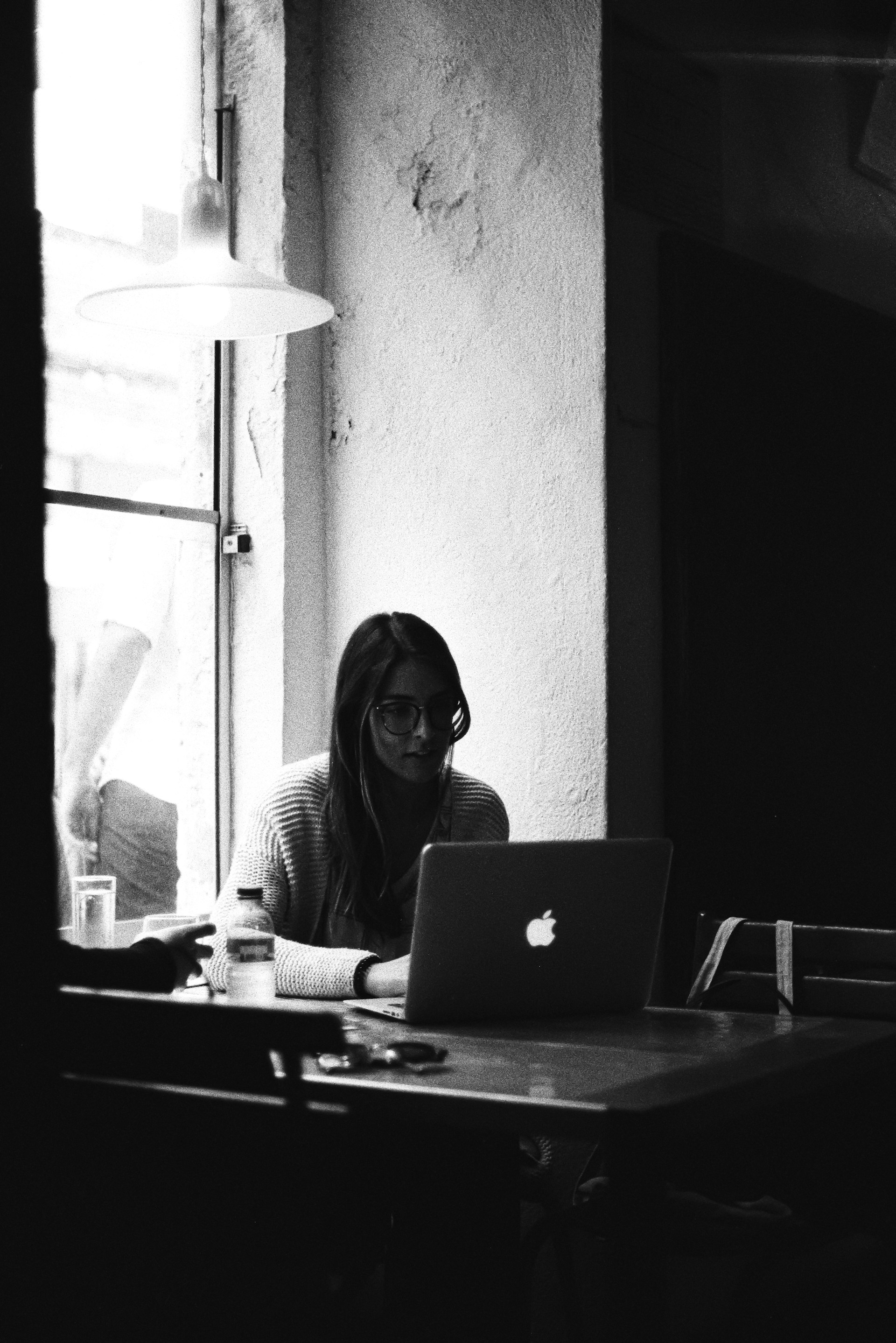 a person sitting at a table with a laptop