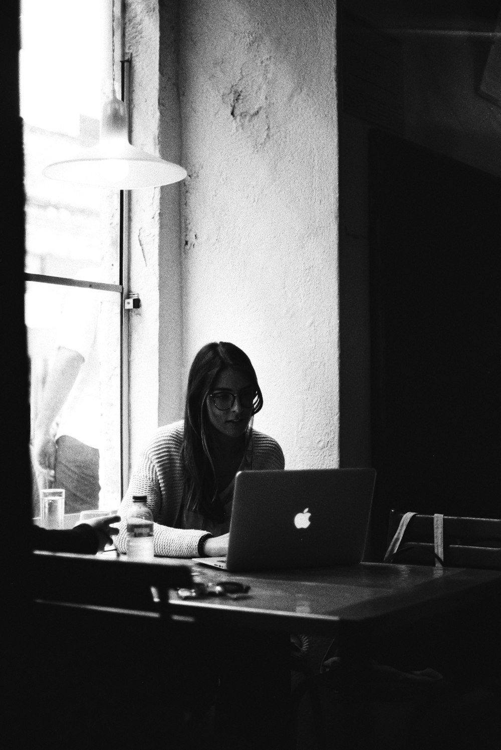 a person sitting at a table with a laptop