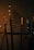A dimly lit coffee shop menu board lists various beverages such as espresso, cappuccino, and chai. The surrounding environment has a cozy, warm ambiance with elements like a counter and decor visible in the background.