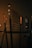 A dimly lit coffee shop menu board lists various beverages such as espresso, cappuccino, and chai. The surrounding environment has a cozy, warm ambiance with elements like a counter and decor visible in the background.