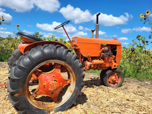 A rustic tractor parked in a sunny Italian farm field near San Martino Buon Albergo.