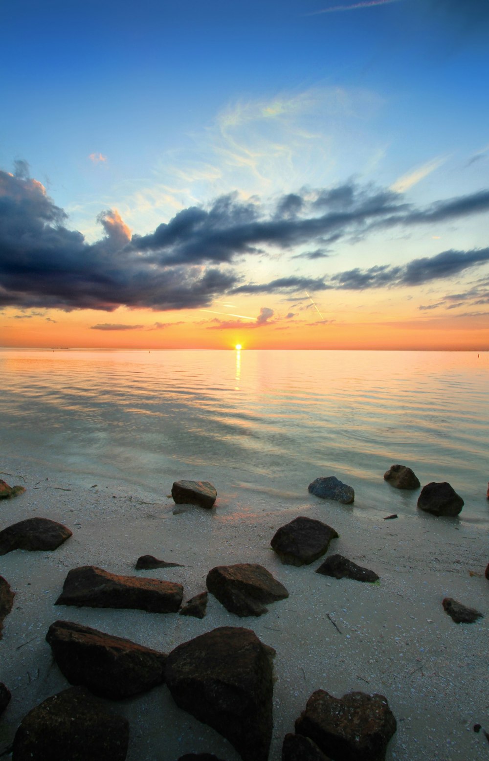 Une plage rocheuse avec un coucher de soleil