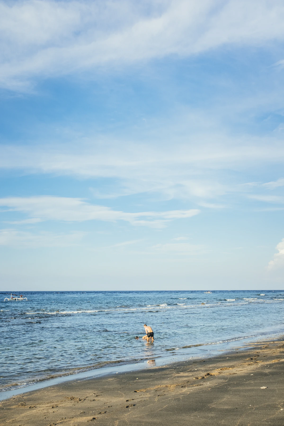 Traditional wooden outrigger boats and black sand bays beneath Mount Agung in Amed
