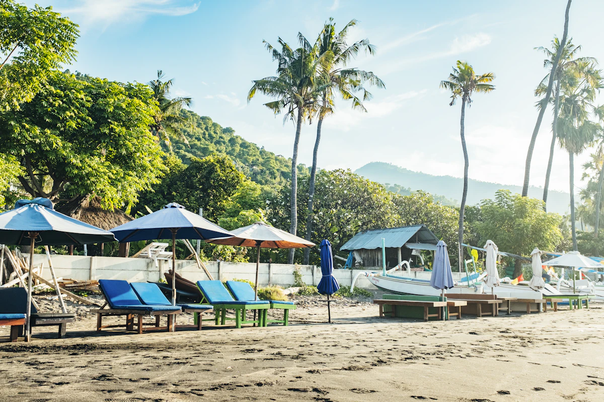 Traditional wooden outrigger boats and black sand bays beneath Mount Agung in Amed