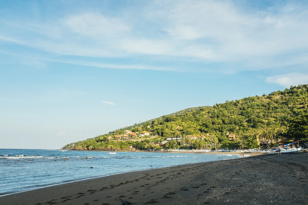 Traditional wooden outrigger boats and black sand bays beneath Mount Agung in Amed