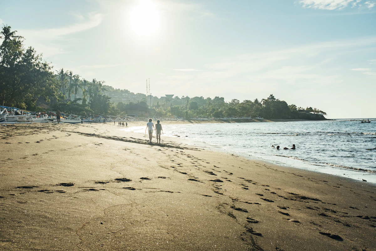 Traditional wooden outrigger boats and black sand bays beneath Mount Agung in Amed