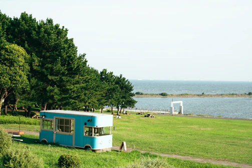 A vibrant food truck parked by the North Shore beach with a custom website displayed on a tablet