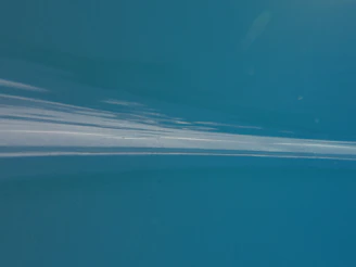 Still from the music video for 'Floating Again' showing a cinematic underwater scene with soft gradients of blue.