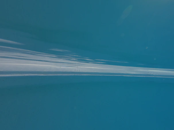 Still from the music video for 'Floating Again' showing a cinematic underwater scene with soft gradients of blue.