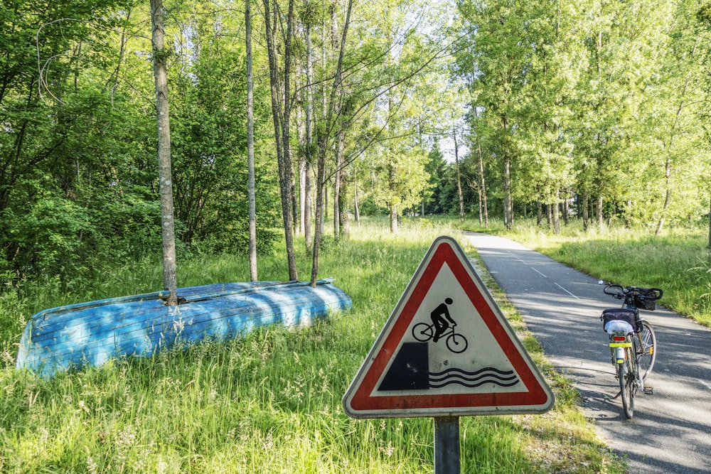 a bicycle parked next to a sign