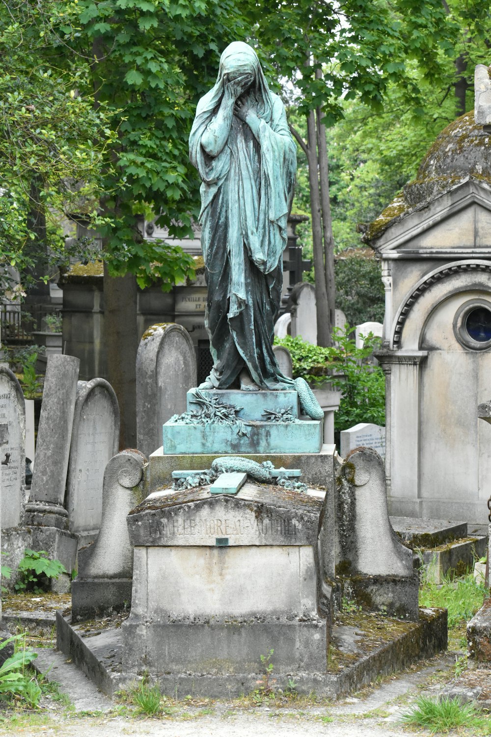 eine Statue einer Person auf einem Friedhof