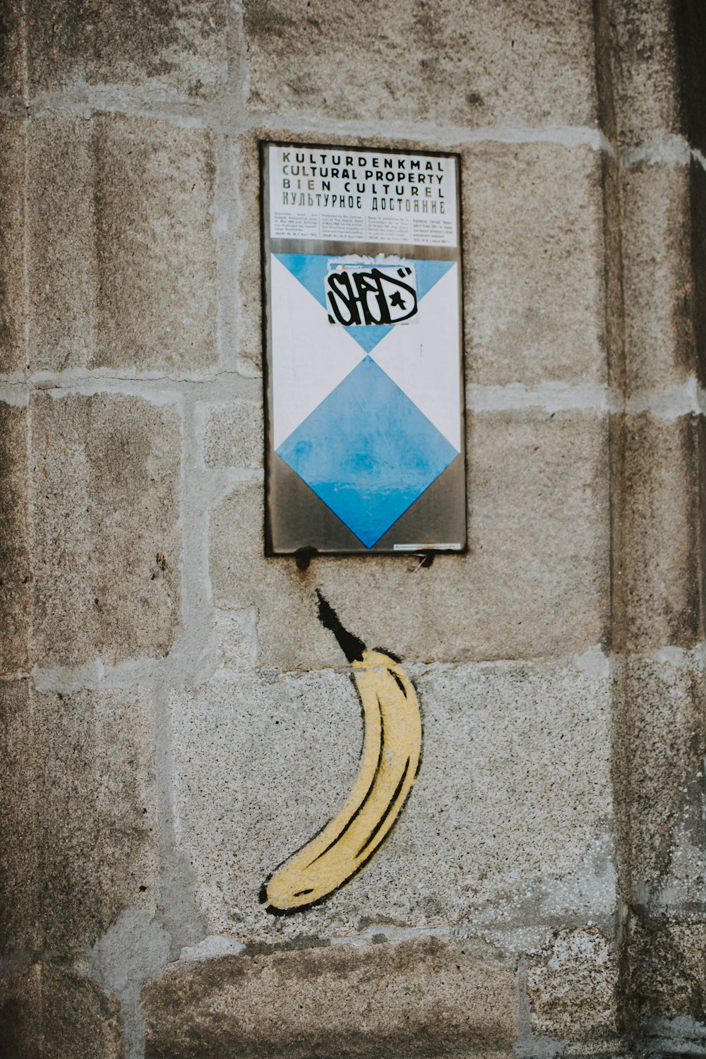 a banana and a sign on a wall