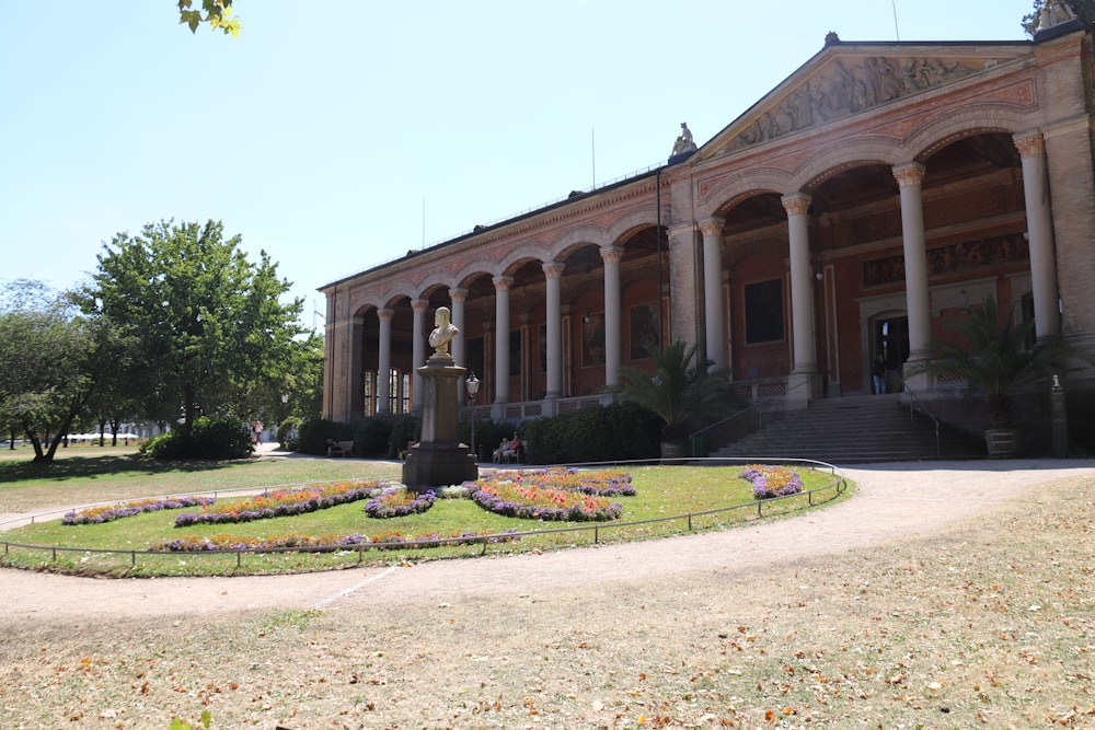 a large building with columns and a garden in front of it