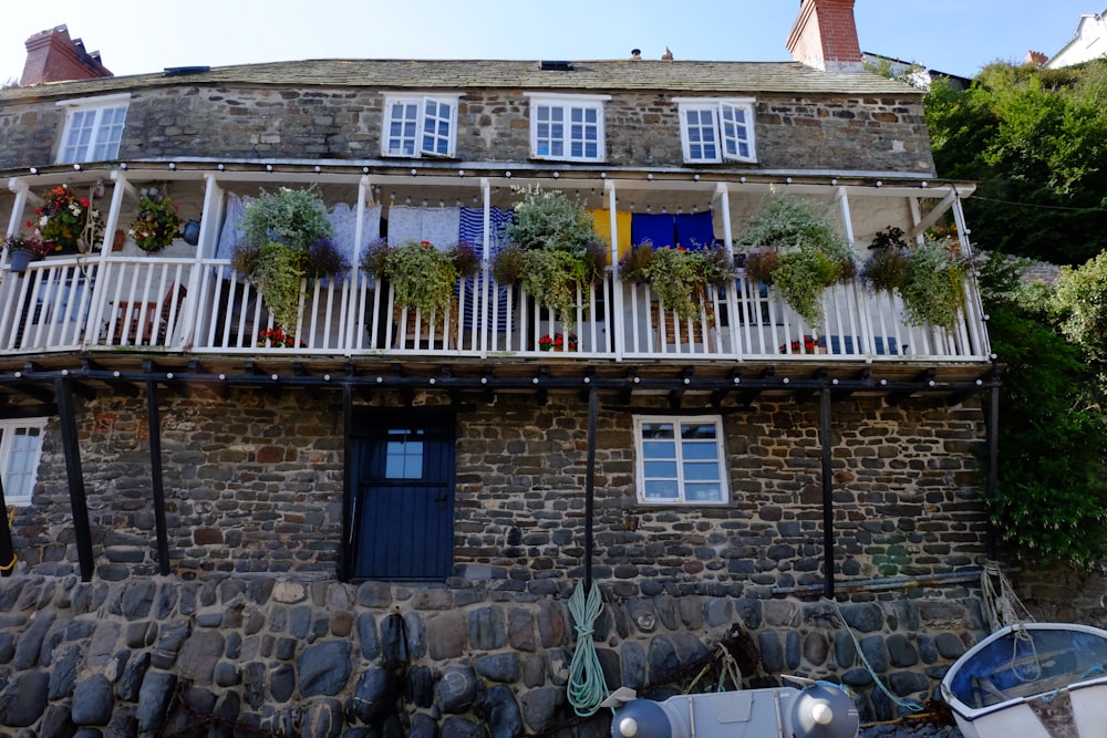 Ein Haus mit einer Steinmauer und einem Zaun mit einem Haus im Hintergrund