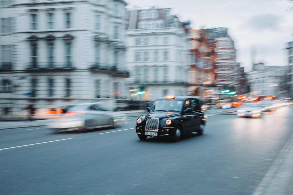 a black car driving down a street