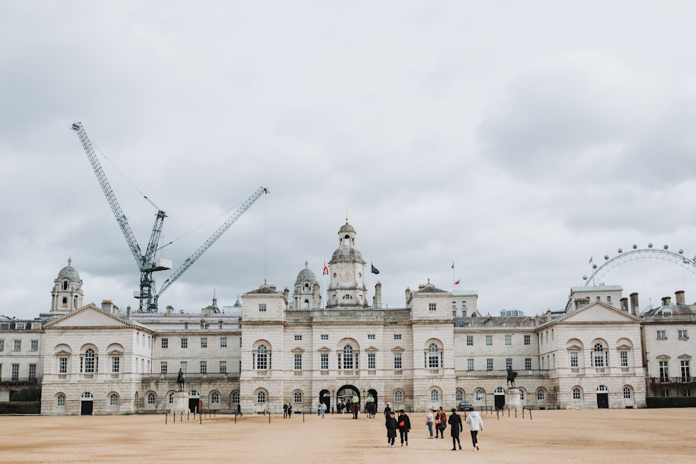 a large building with cranes in the background