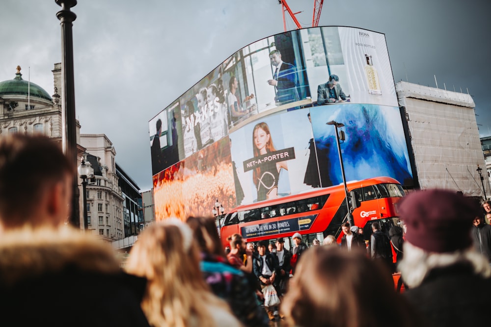 a large crowd of people in front of a large billboard