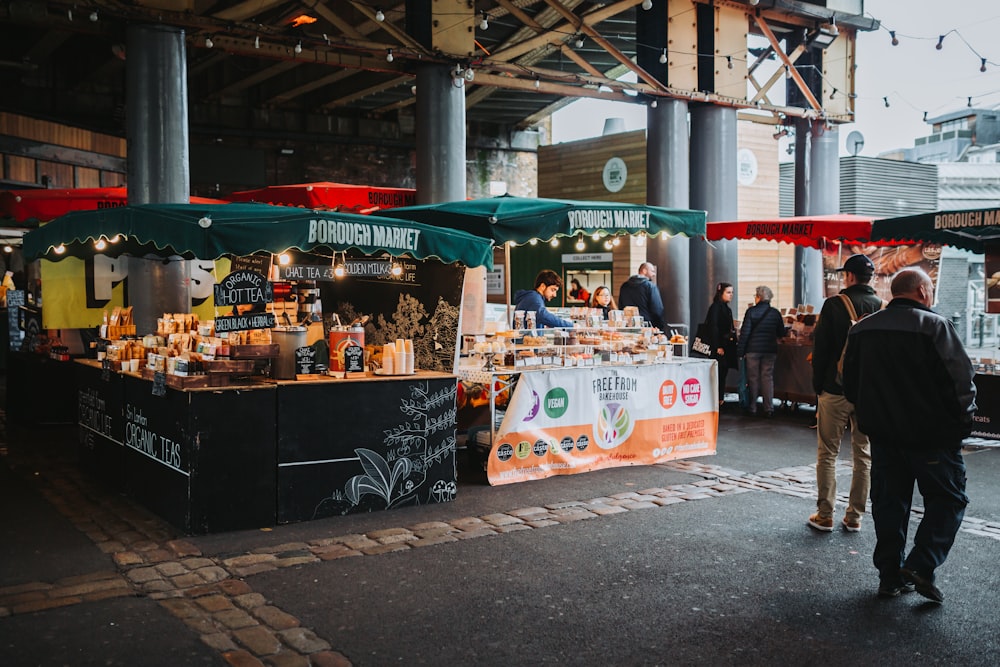 a group of people stand outside a food stand