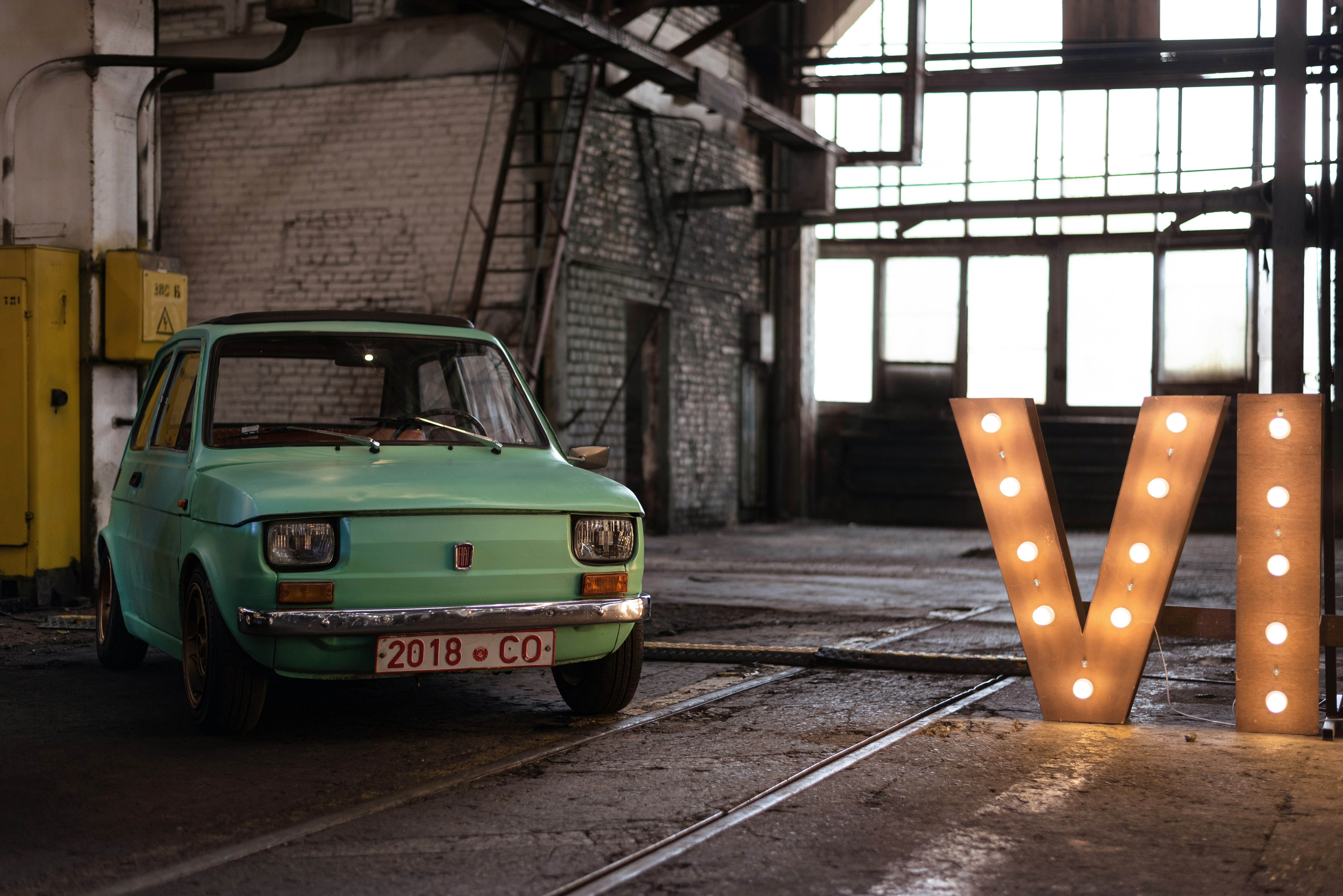 a green car parked in a warehouse