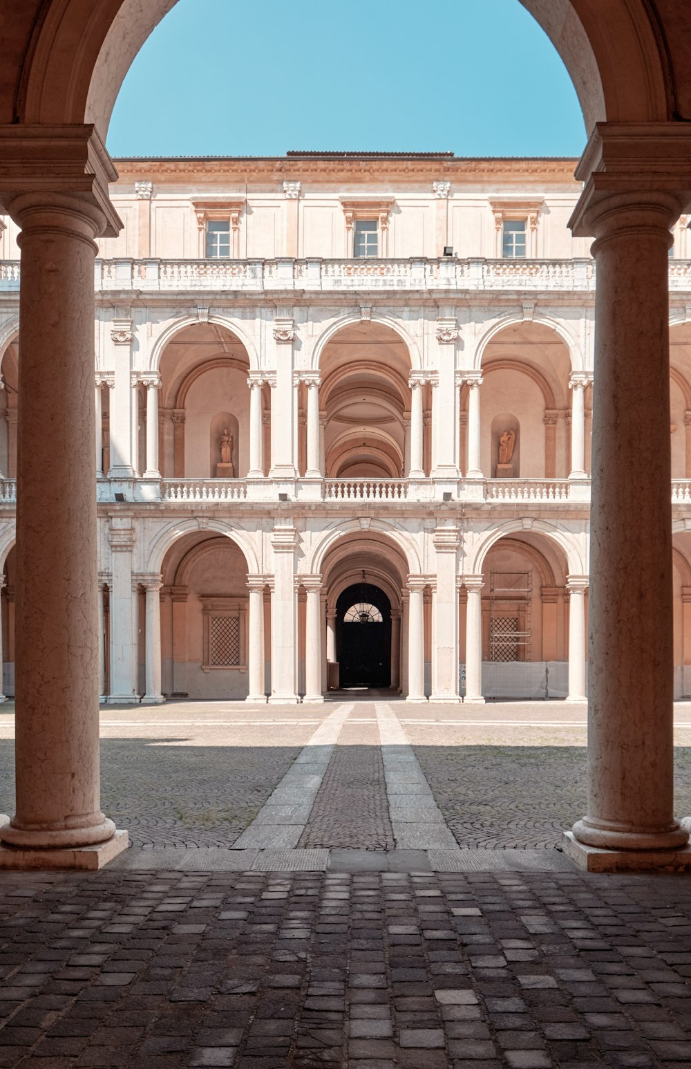 a building with pillars and a brick walkway