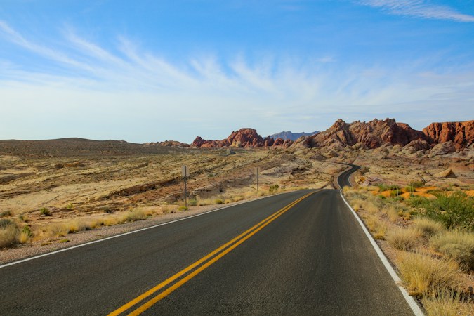 A two lane road running through open desert land under a wide sky, the kind of raw acreage found around Apex Industrial Park north of Las Vegas