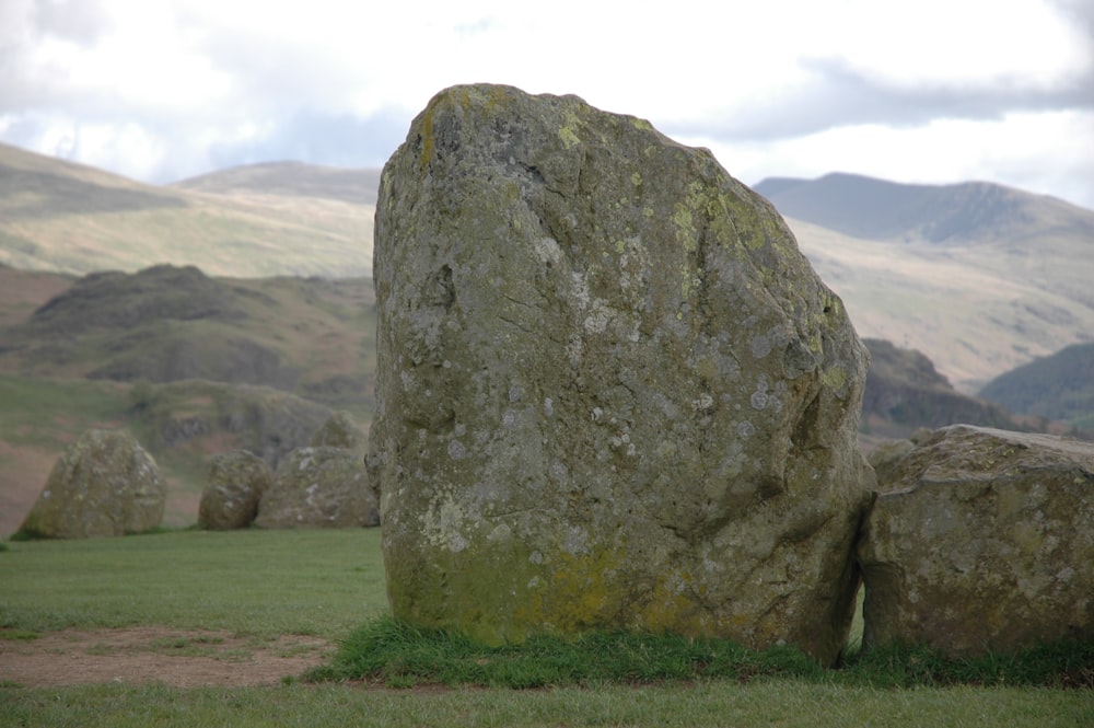 a large rock in a grassy field