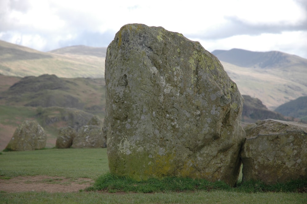 una gran roca en un campo cubierto de hierba