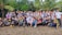A group of diverse people smiling together on a beach, symbolizing community and solidarity.