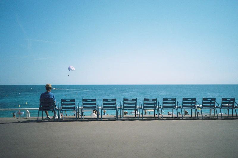 Une personne sur un banc face à la mer au crépuscule à Nice
