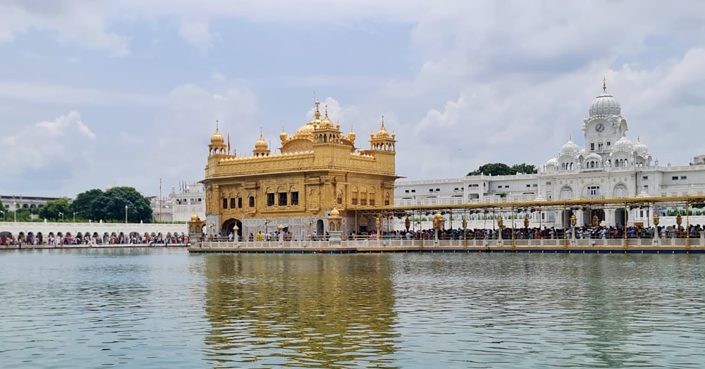 a body of water with Harmandir Sahib in the background