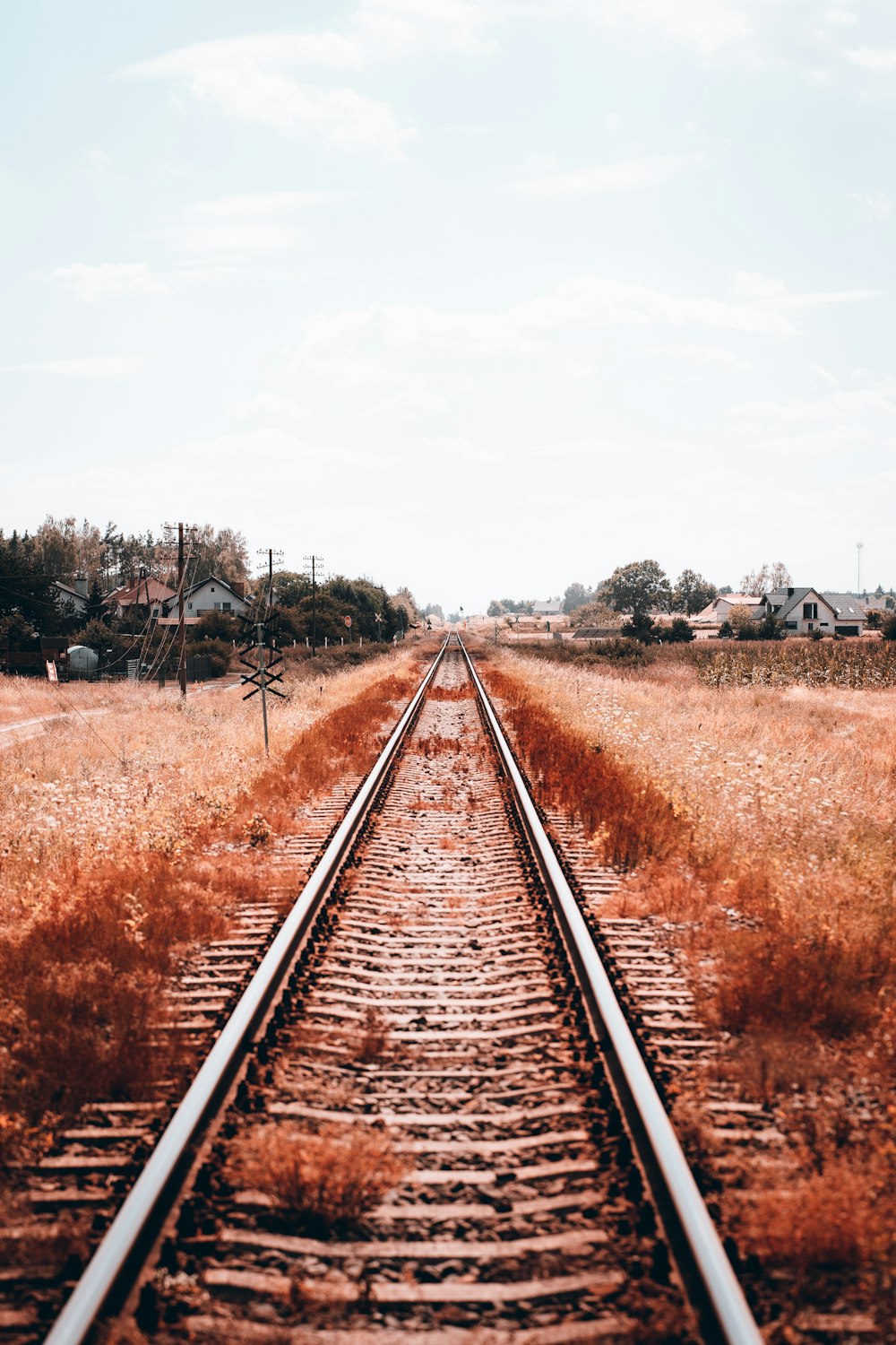 a railroad track with houses in the background