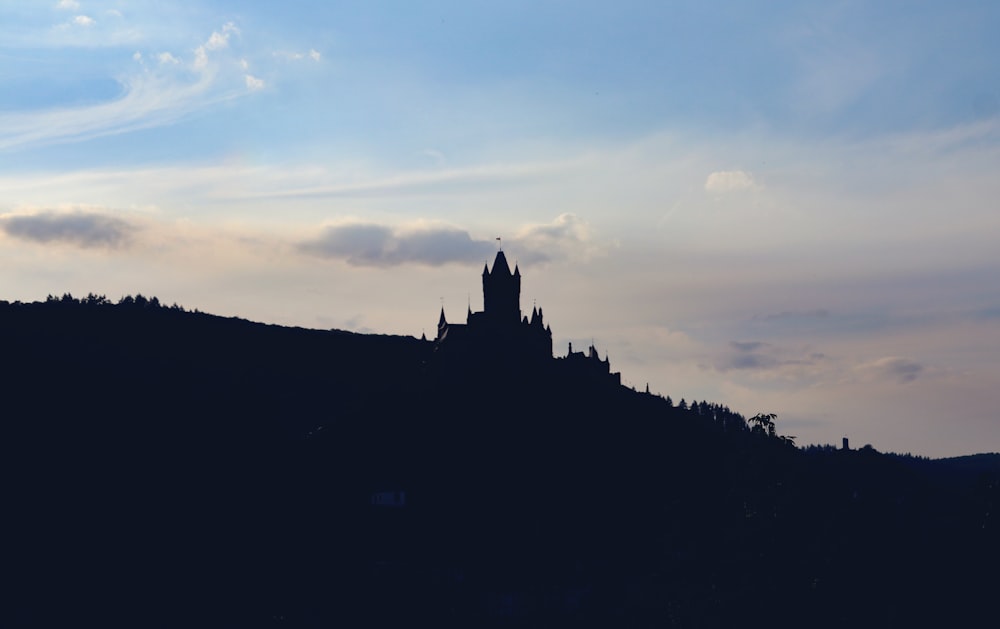 a silhouette of a building on a hill