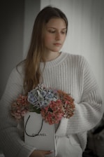 A happy customer holding a rented Chanel bag, smiling in a cozy, stylish living room.