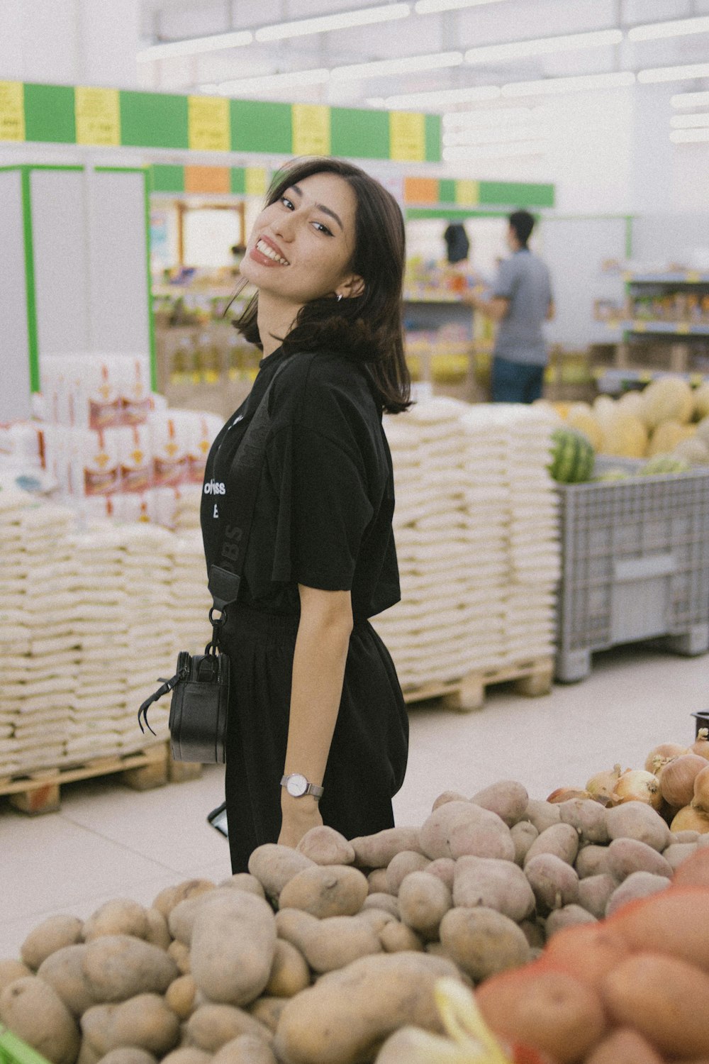 a person standing in front of a pile of potatoes