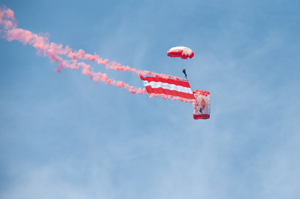 a person in the air with a parachute and a parachute