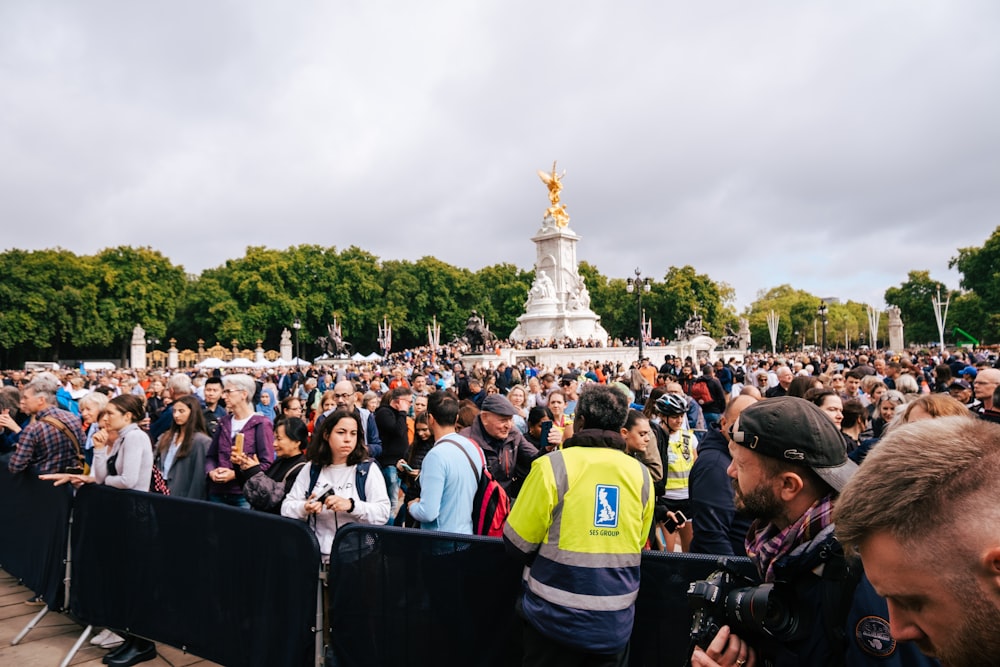 a crowd of people in front of a statue