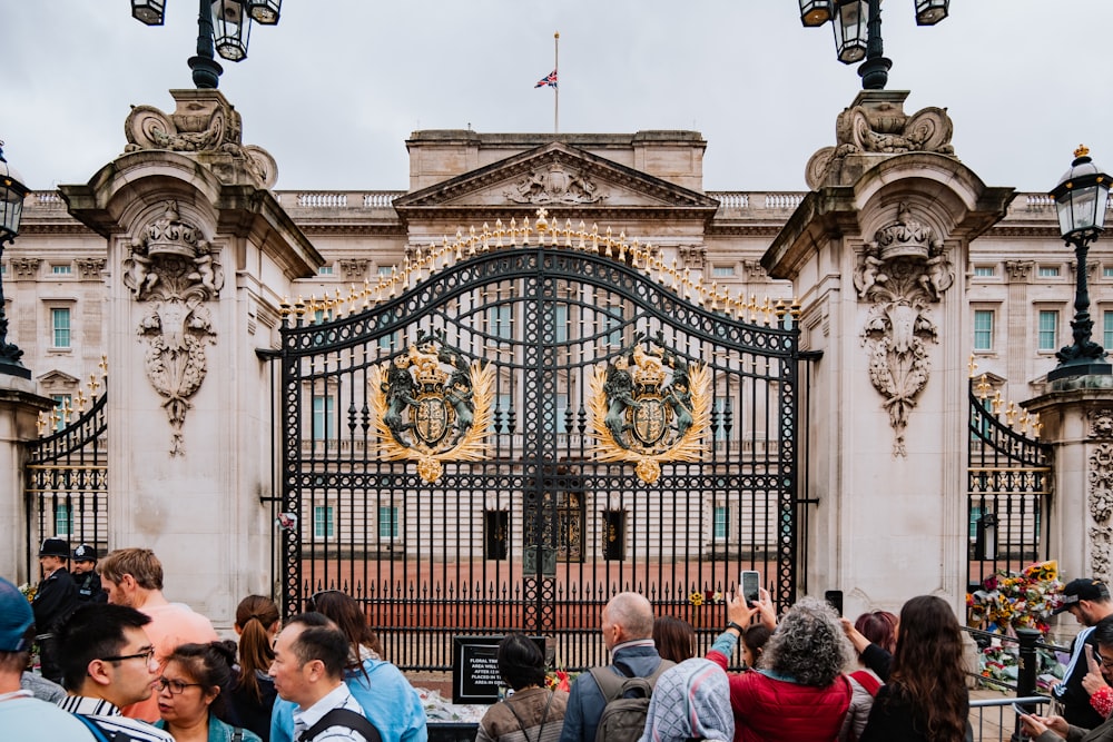 a crowd of people in front of a building with a large clock