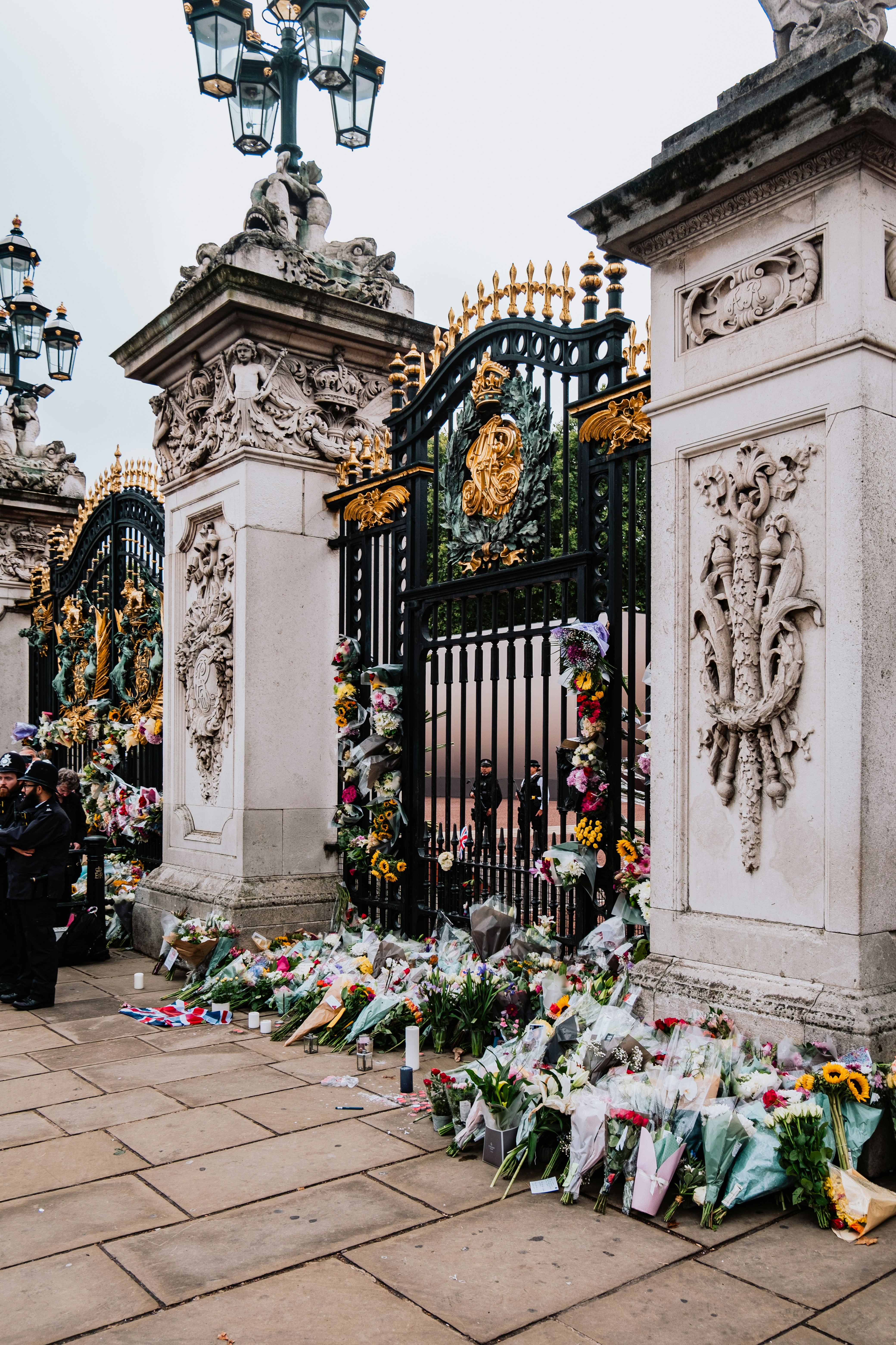 a gate with flowers and a clock on it