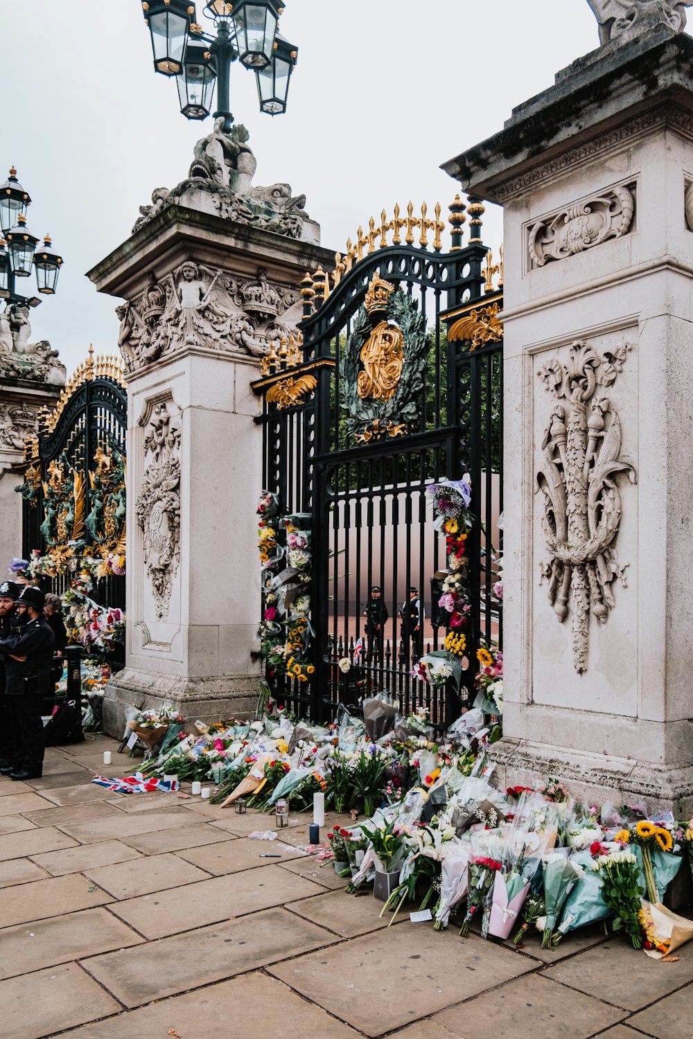 a gate with flowers and a clock on it