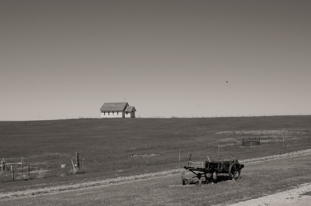 a black and white photo of a farm with a tractor in it