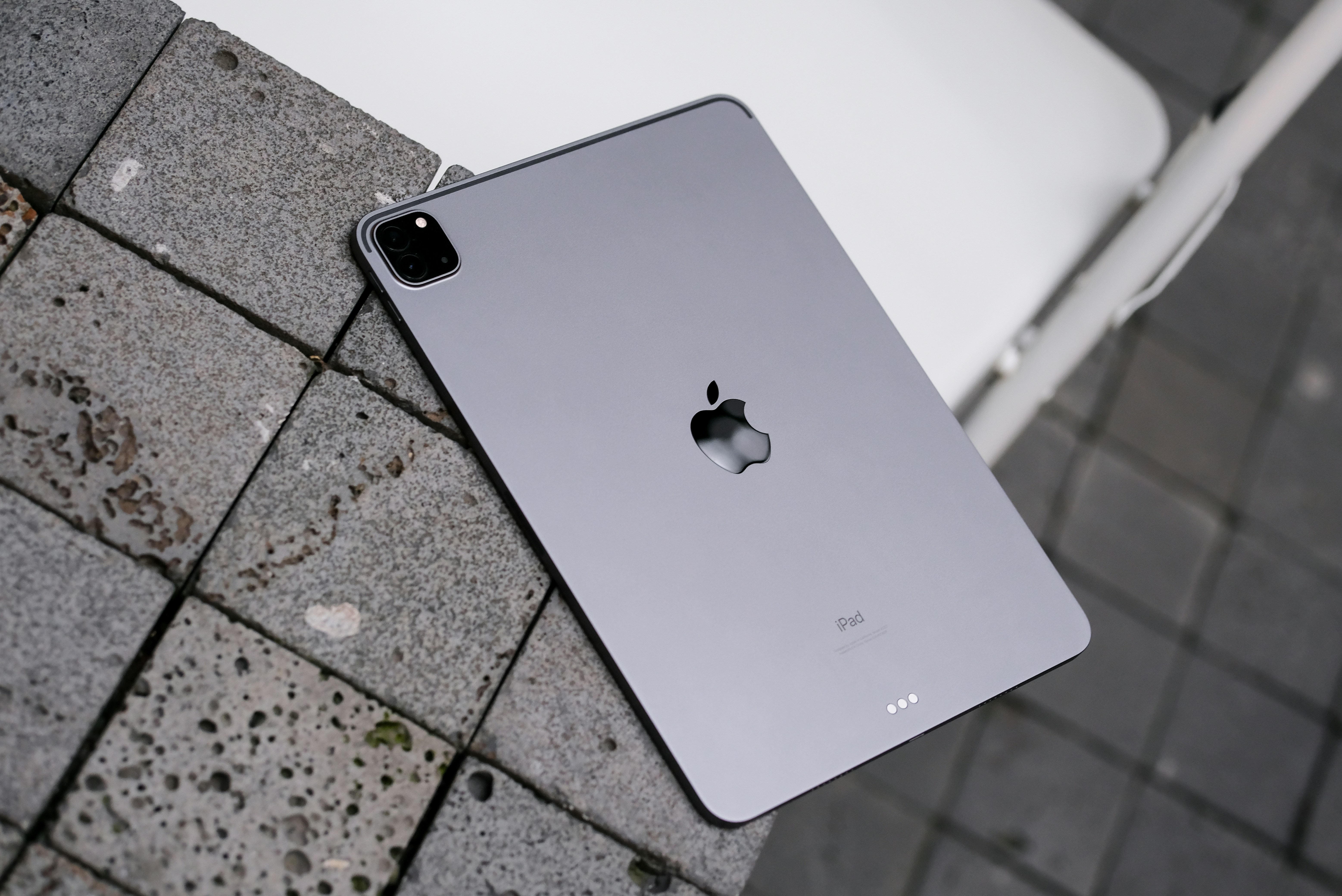 Silver iPad Pro on stone-tiled outdoor surface