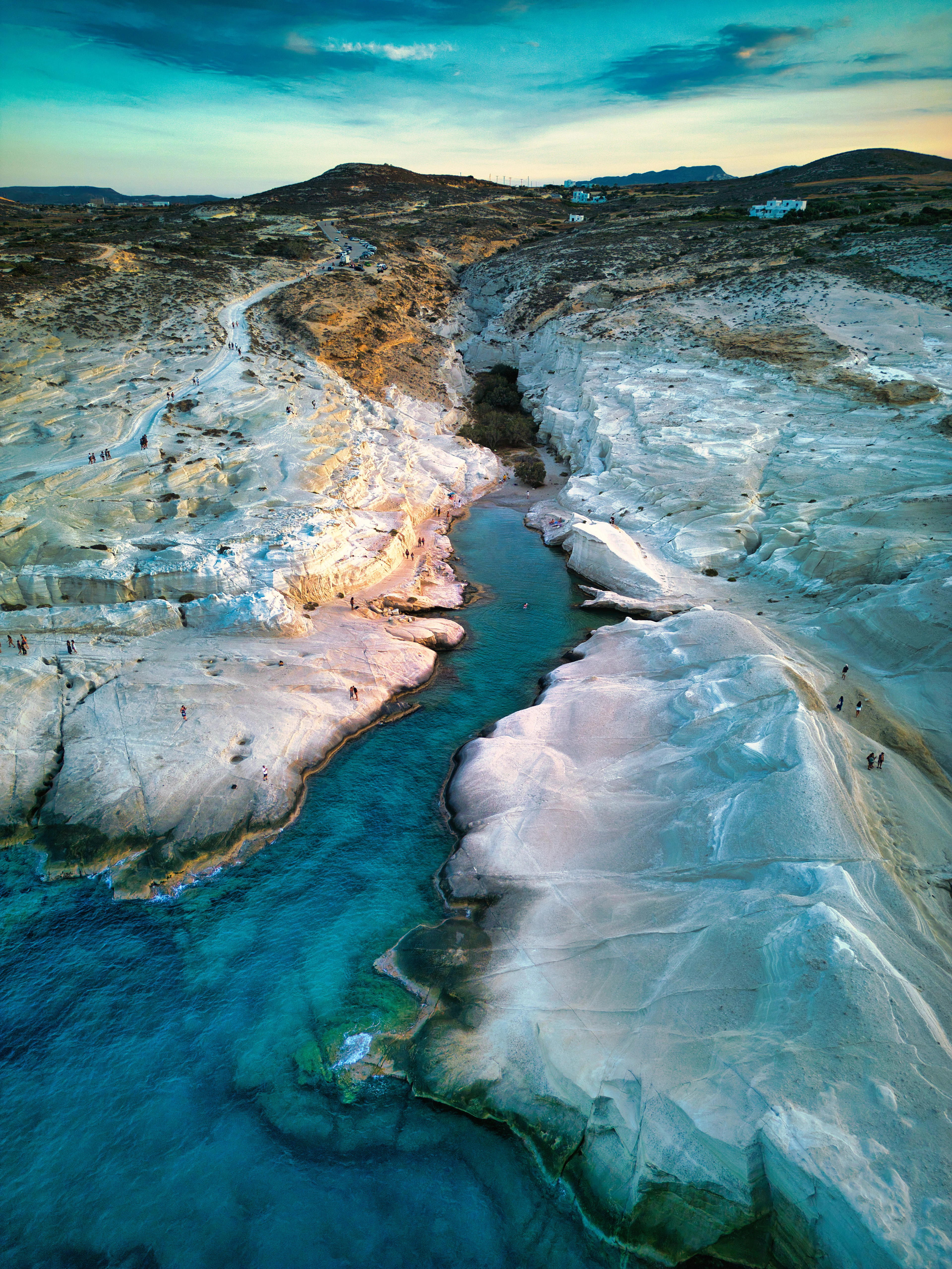 Aerial view of the white volcanic rock and sea channel at Sarakiniko Beach, Milos, at sunset