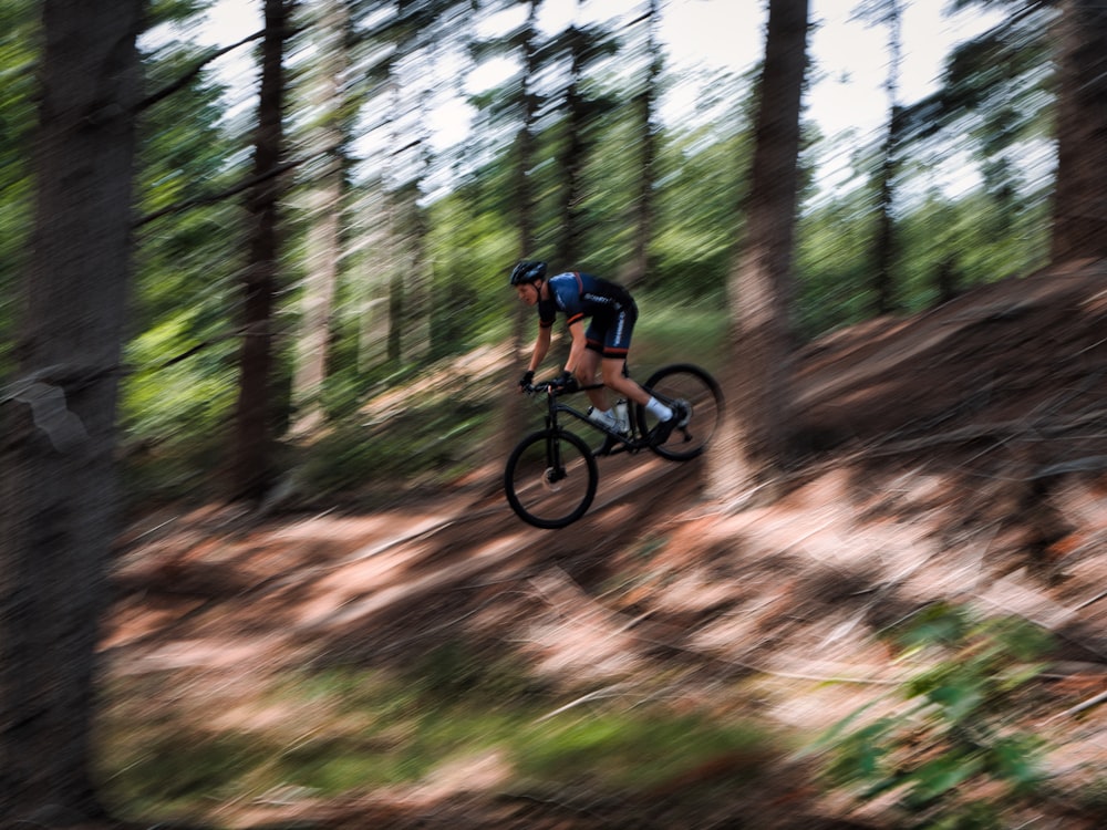 Eine Person, die auf einem Pfad im Wald Fahrrad fährt