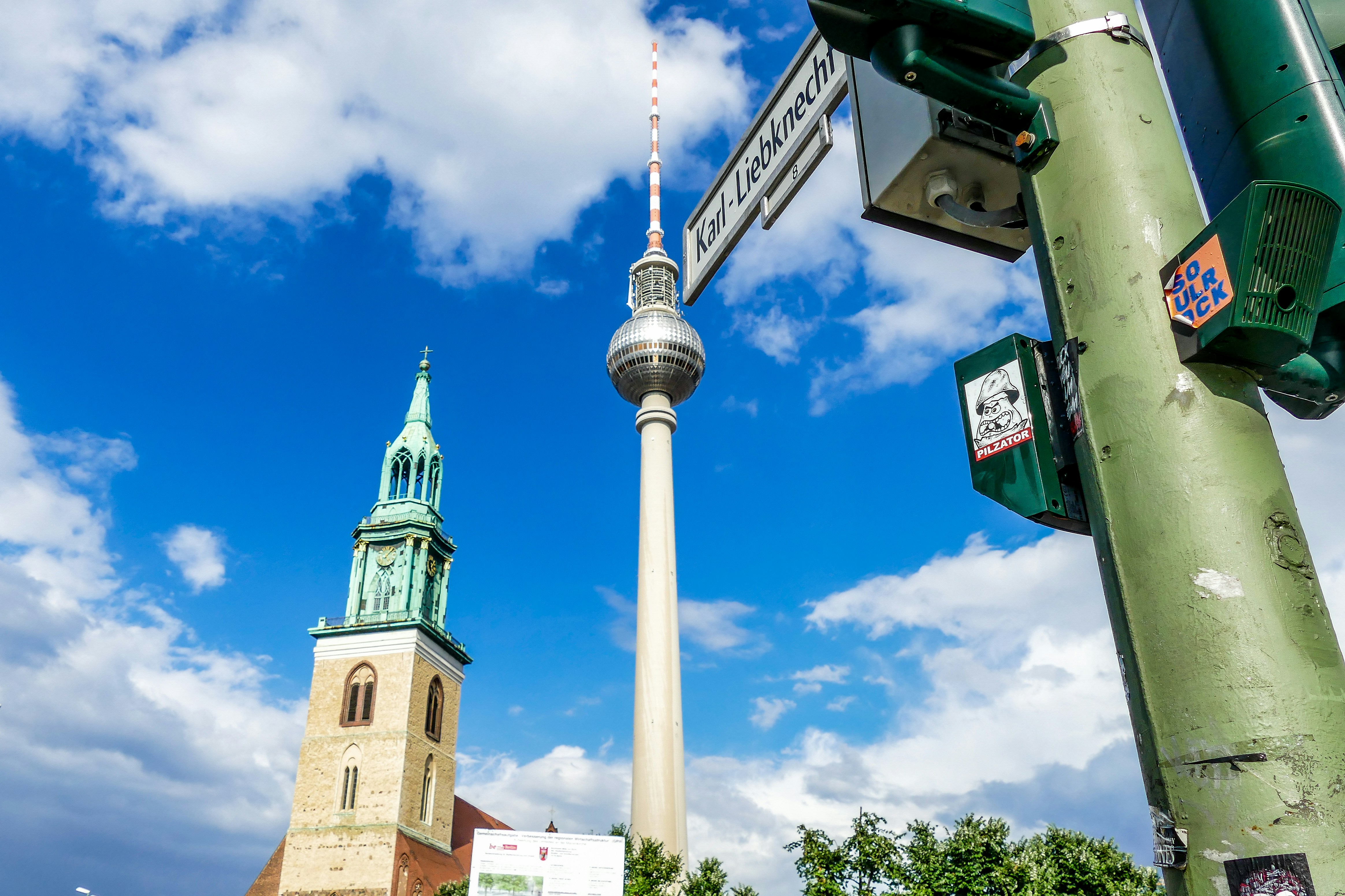 uma placa de rua ao lado de uma torre sineira
