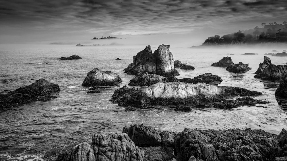 a rocky beach with a body of water in the background