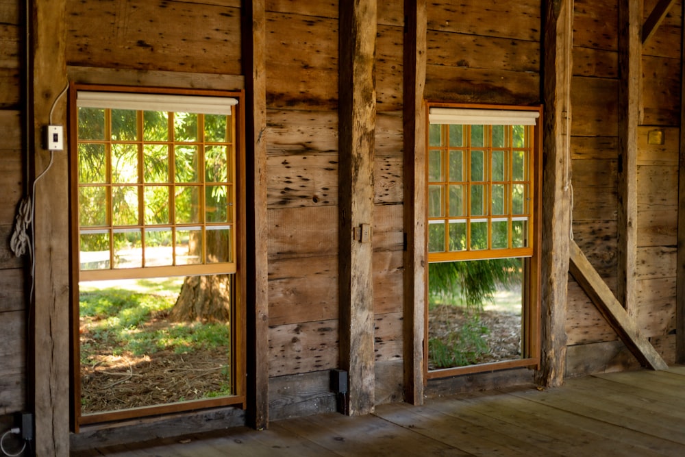 um quarto com janelas e paredes de madeira