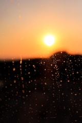 Sunset viewed through a rain-speckled window, soft and calm