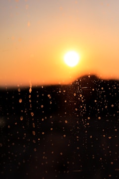 Sunset viewed through a rain-speckled window, soft and calm