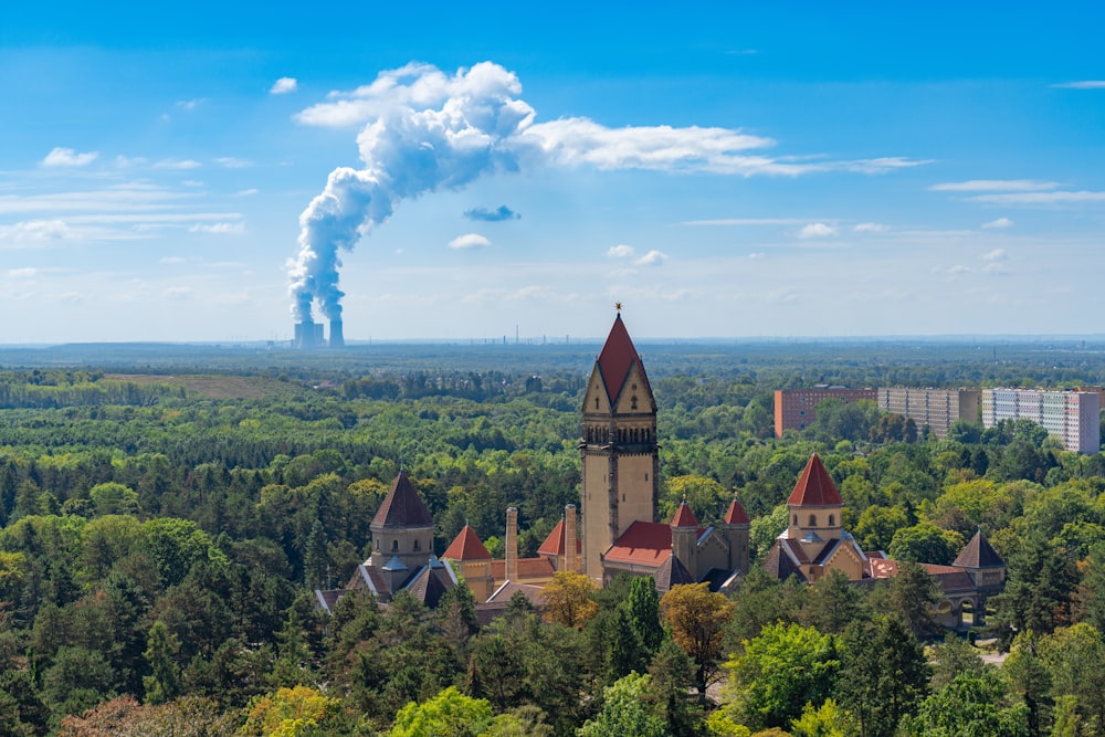 a large building with a tower in the middle of a forest